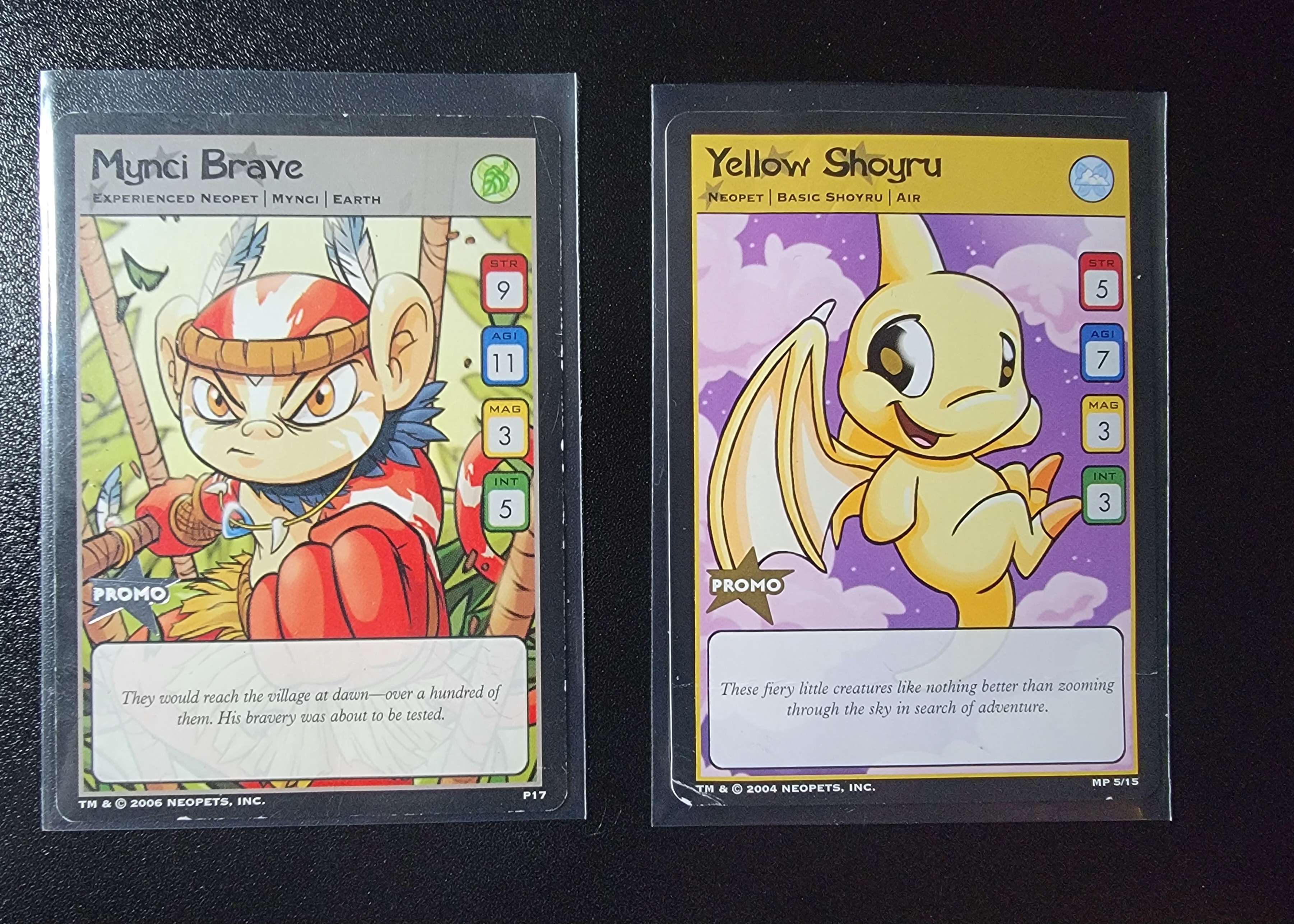 a mynci brave neopets trading card, and a yellow shoyru neopets trading card.