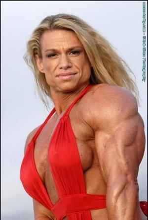 Female bodybuilder Tina Chandler models red swimwear on a beach