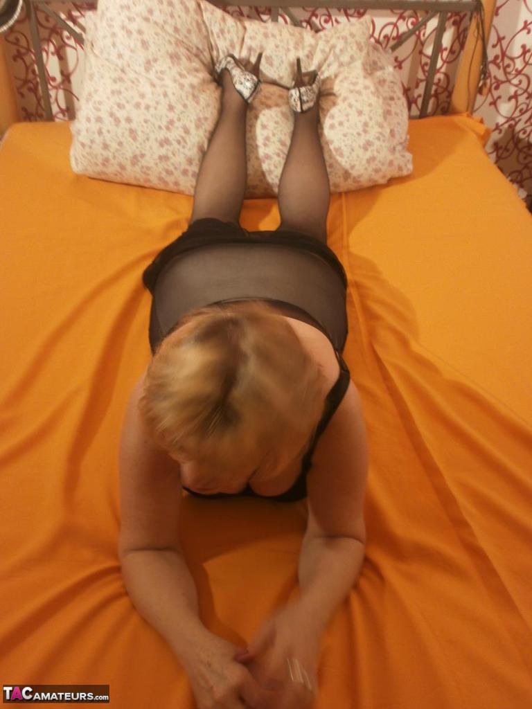 Tipsy hot granny Caro spreading legs on the bed wearing black stockings(9)