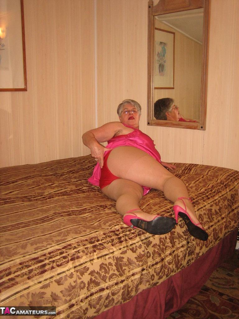 Silver haired nan Girdle Goddess pulls her hose down around her knees on a bed(8)