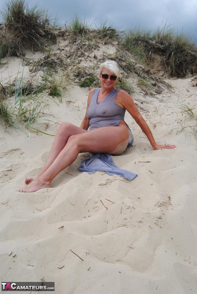 Beautiful busty mature Dimonty poses fully clothed in sheer dress at the beach(7)