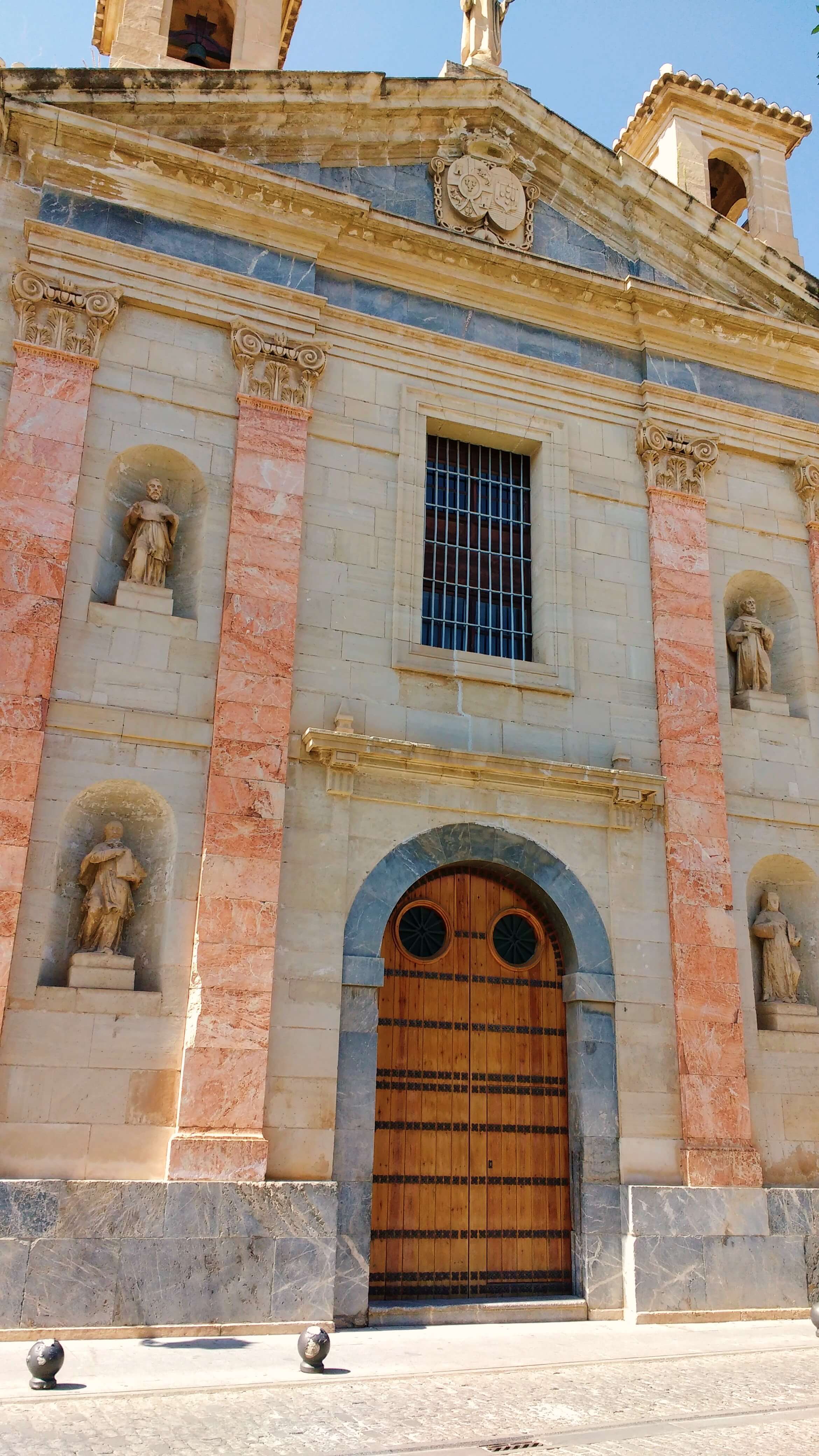 An grand white building with statues built into its niches