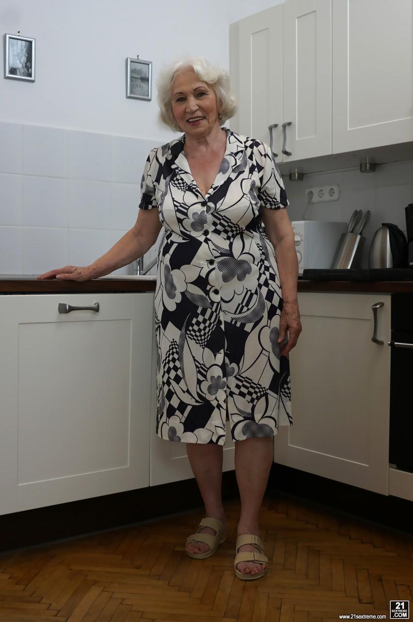 Freaky old blonde granny named Norma showing her tits in the kitchen(1)