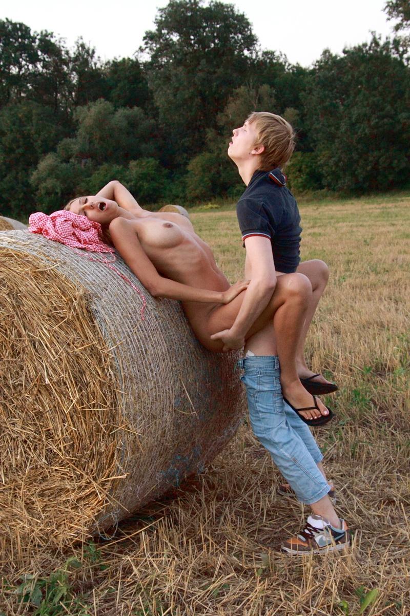 Horny young couple have sexual intercourse against a round bale in a field(7)