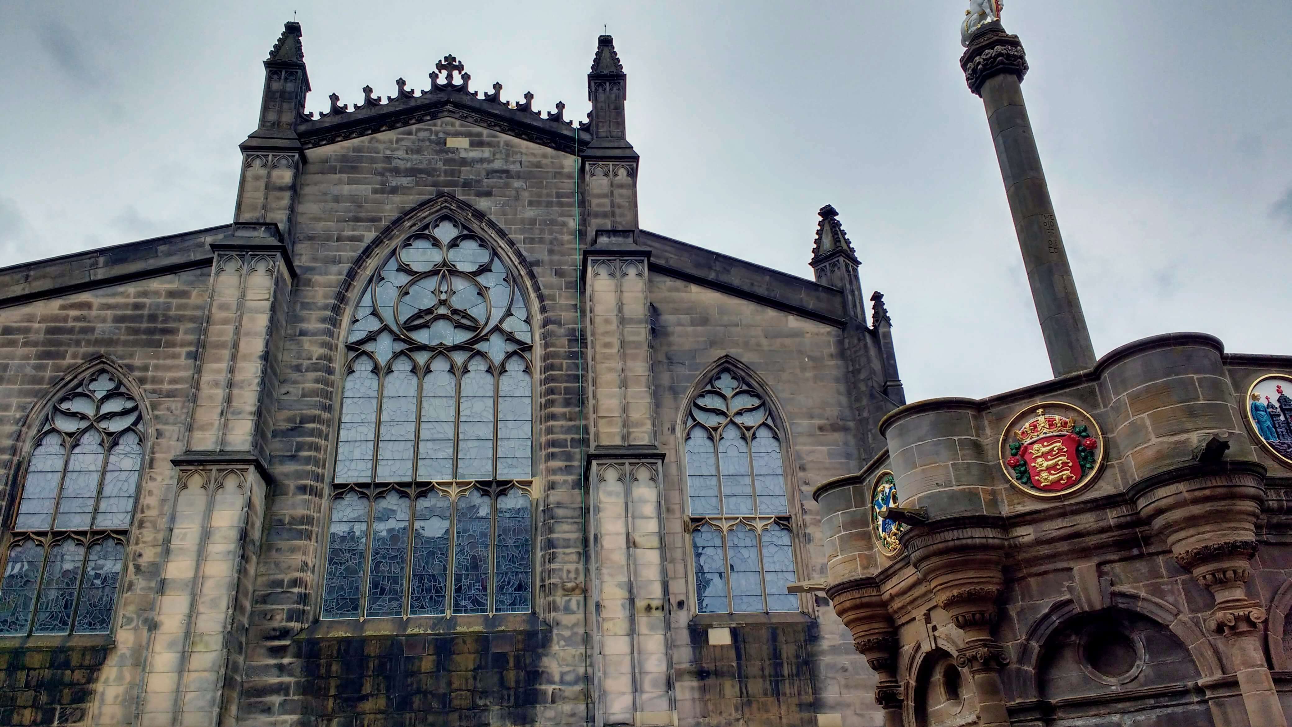 A gothic church behind a smaller stone structure