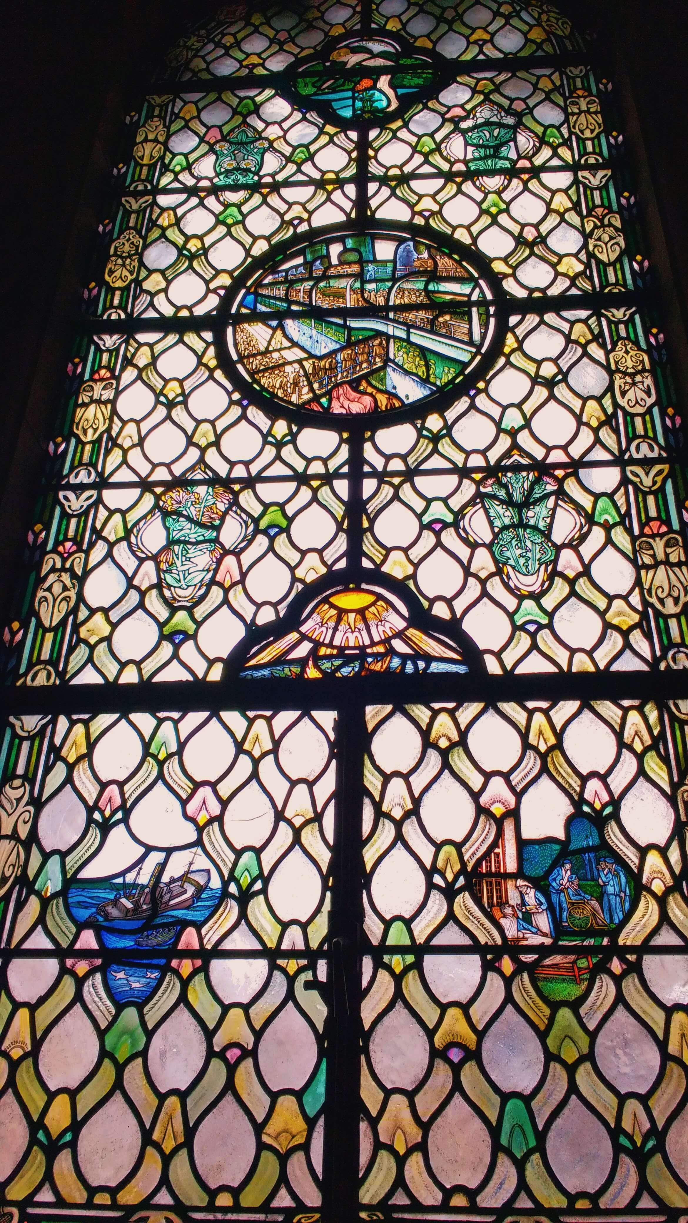A tall brightly lit stained glass window