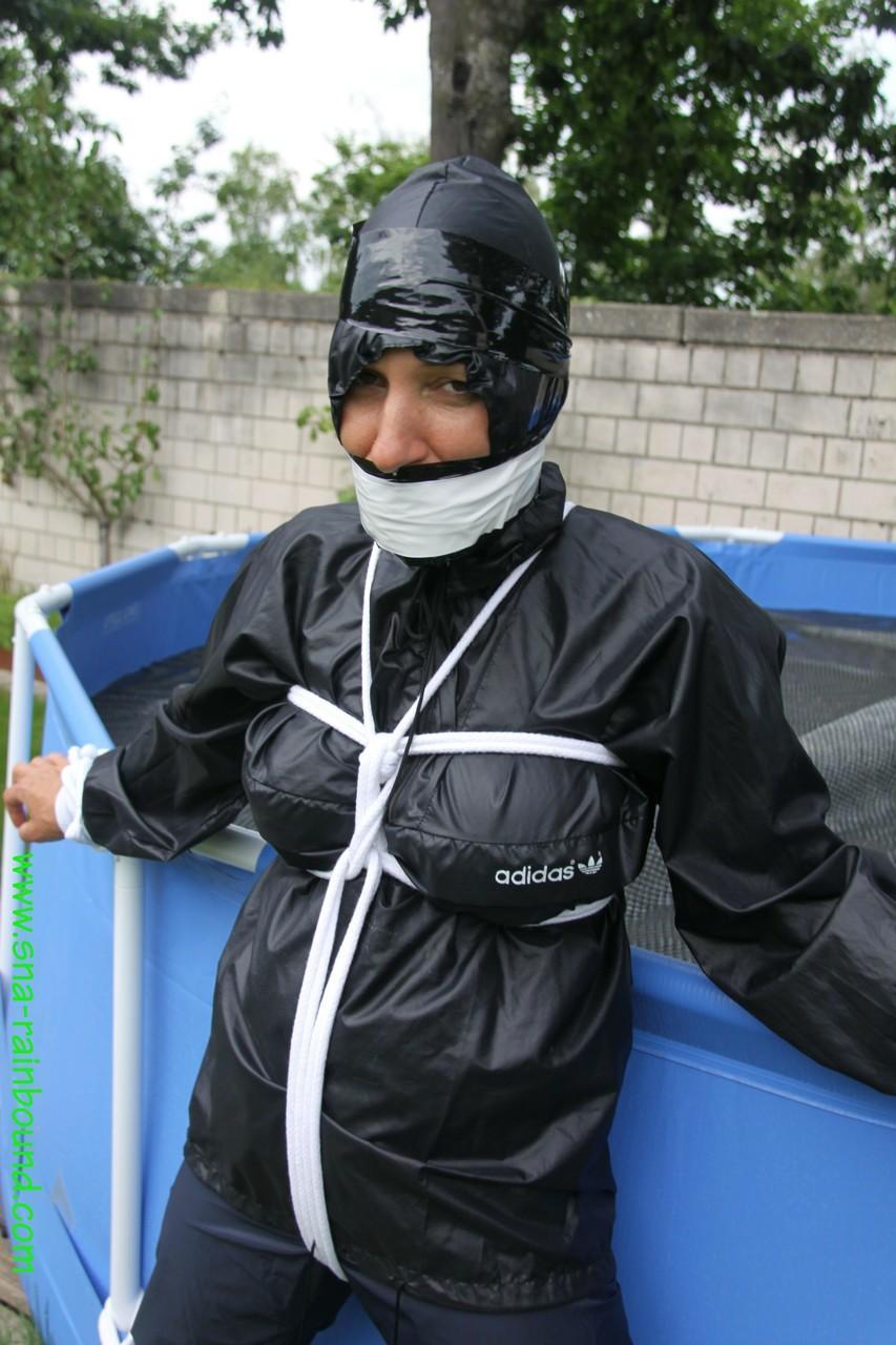 Amateur woman Sandra is gagged and tied to a pool in a raincoat(15)