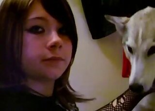 Dark-haired emo girl is having lots of fun with a cute white dog.mp4