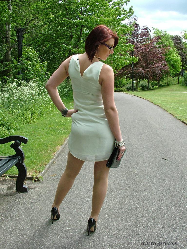 Thick woman in glasses shows off her stiletto heels on a park bench(2)