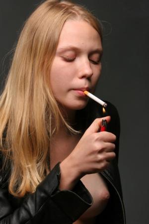 Erotic teen Polly A shows her boobs and pussy while smoking a cigarette