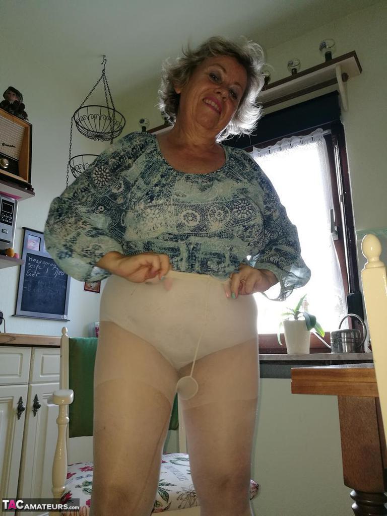 Horny granny Caro sticks a banana inside her natural pussy on kitchen chair(16)