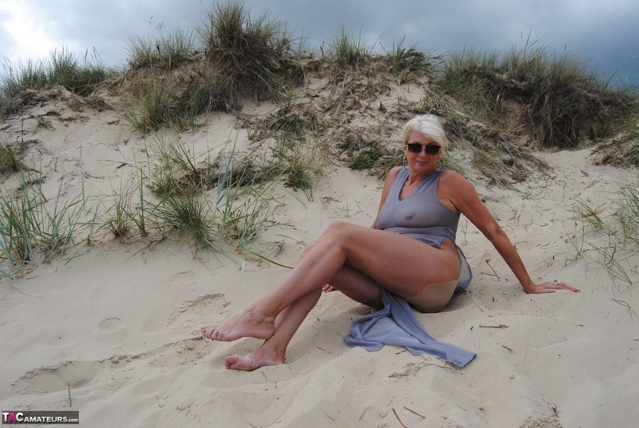 Older blonde amateur Dimonty models at the beach in see thru attire and shades(1)