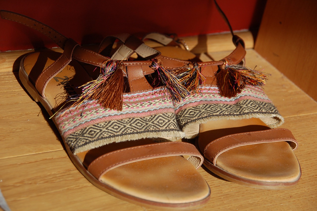 Close-up shot of tasselled sandals on wood flooring