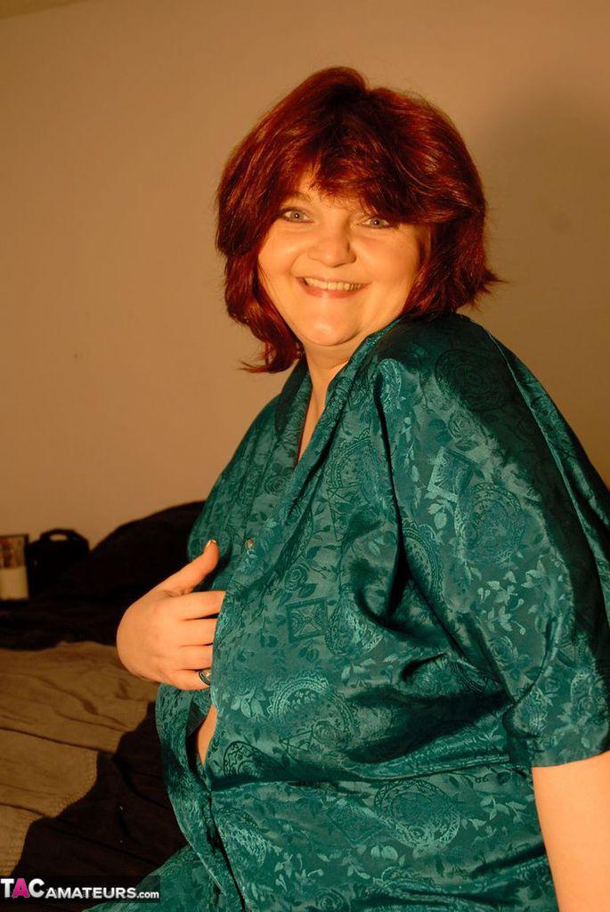 Mature BBW with red hair fondles her massive boobs as she gets undressed(4)