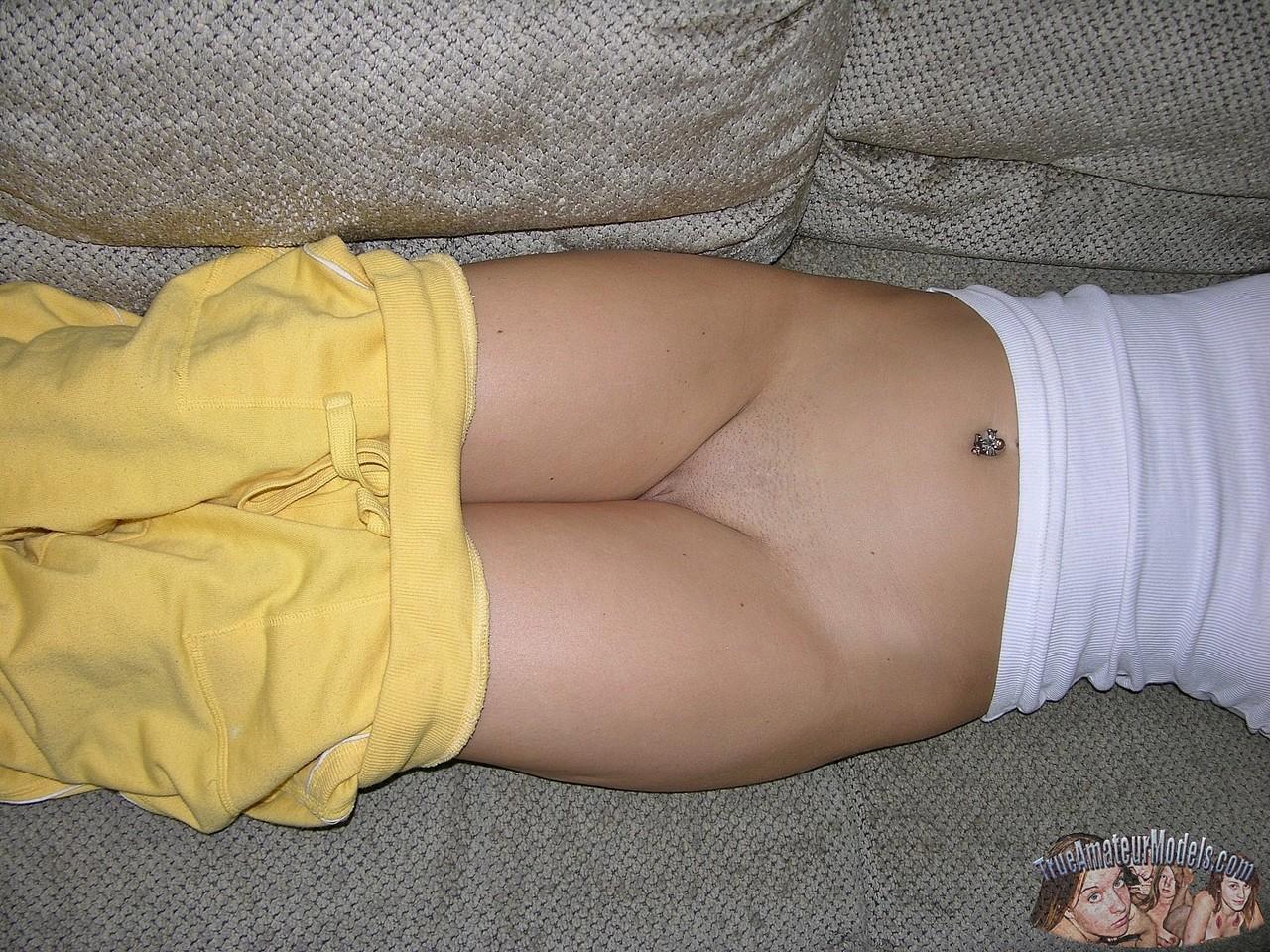 Amateur girl with freckles bares her bum and shaved twat on a living room sofa(10)