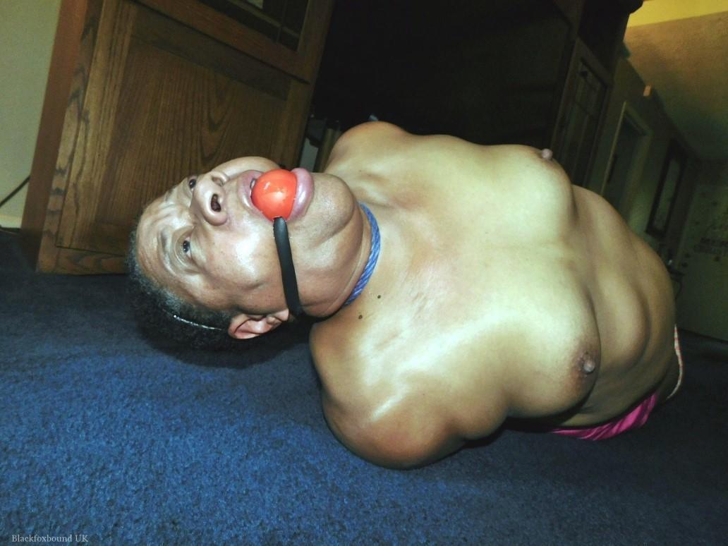 Overweight black woman Trixie struggles against a ball gag while hogtied(2)