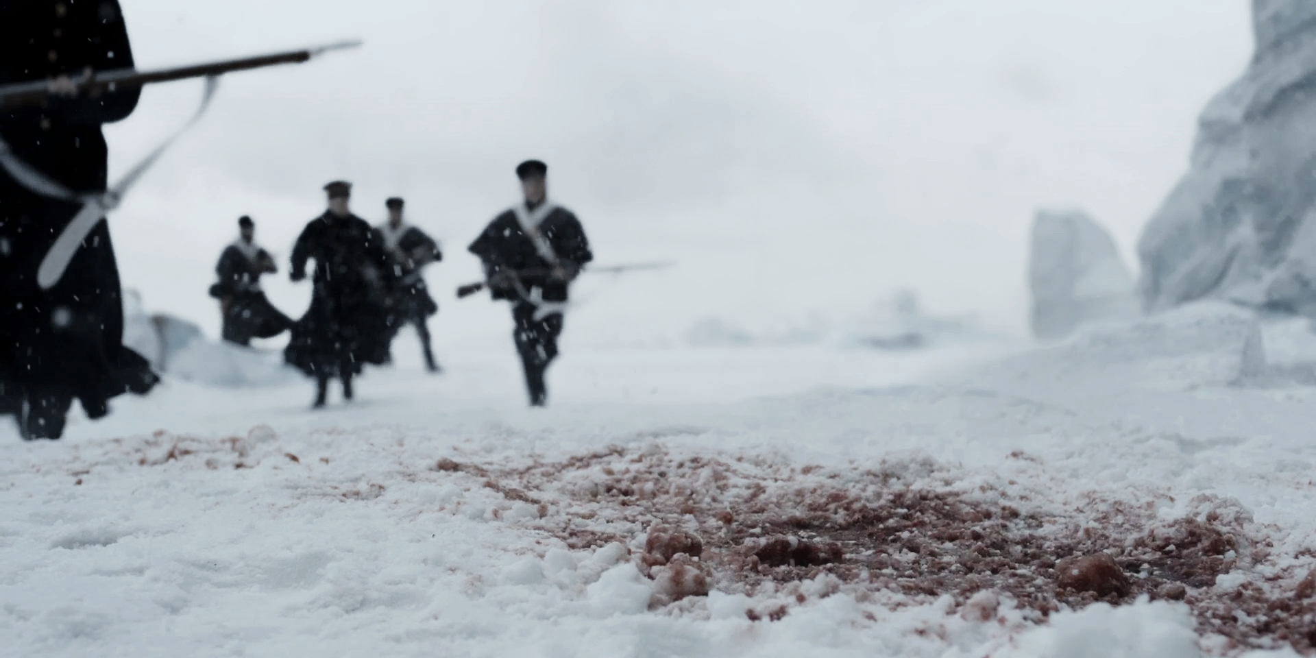 People running past a pool of blood in the snow