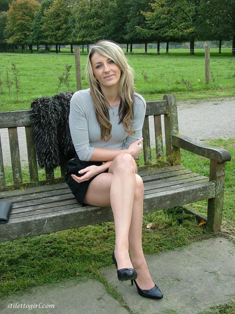 Leg model poses on a country bench in black skirt and pumps(9)