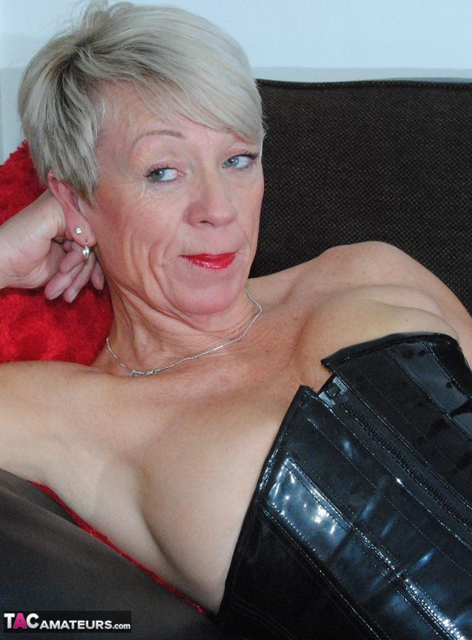 Hot mature Shazzy B in latex & boots displays her big saggy boobs on the couch(1)