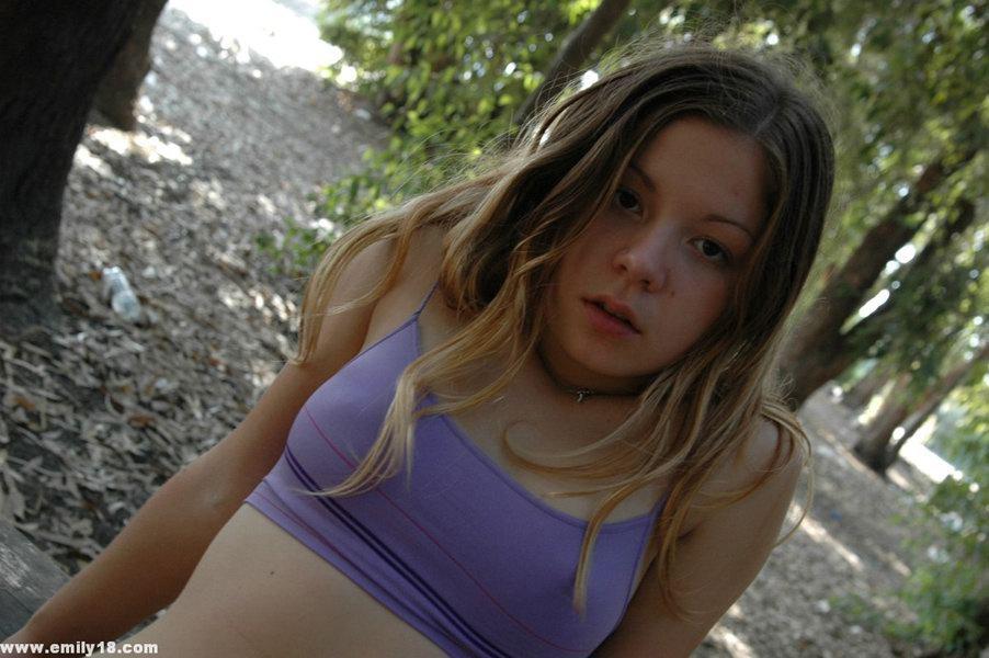 Young looking girl licks her lips while teasing at a park on a picnic table(9)