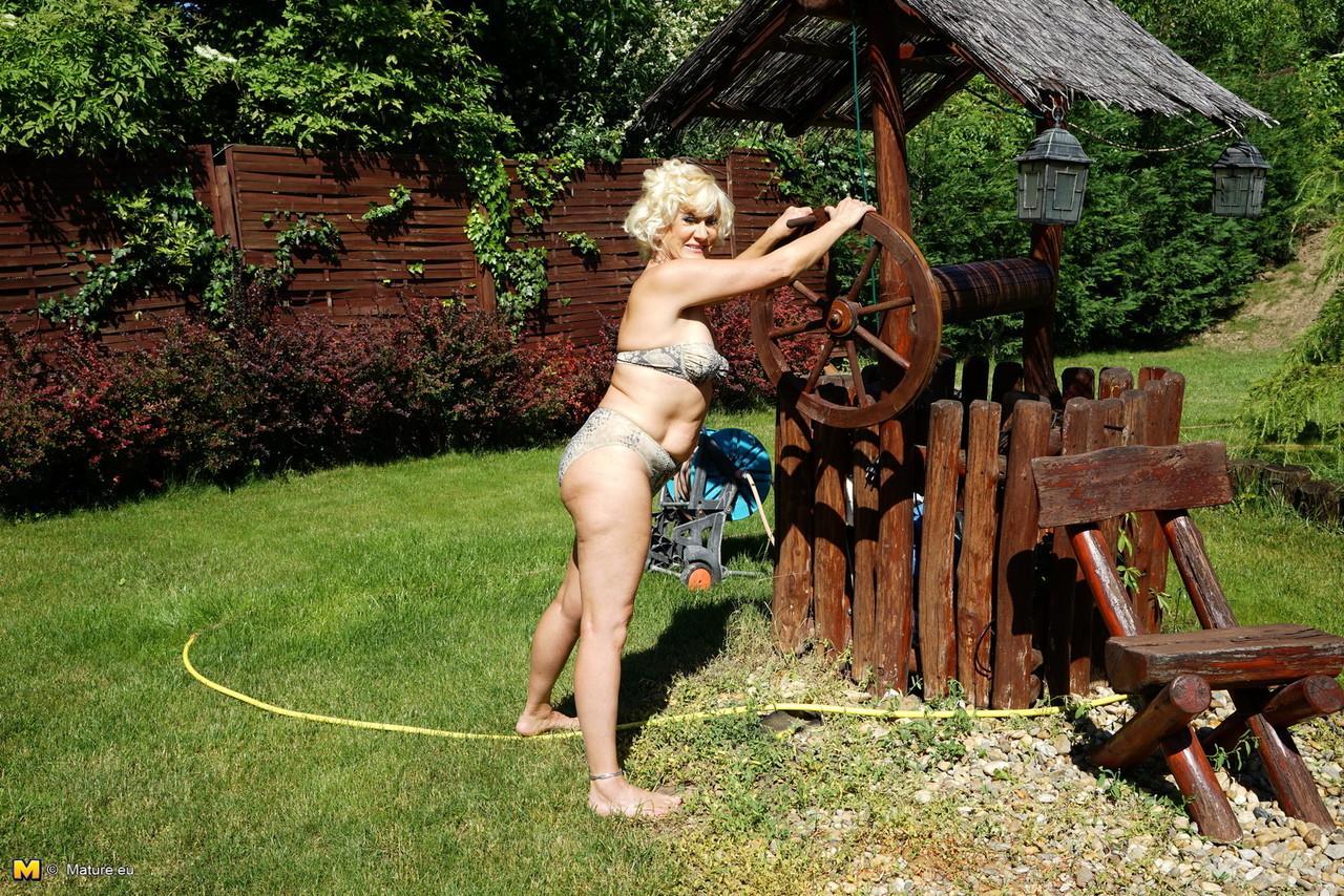 Mature blonde woman takes off her bikini while wandering around her property(2)