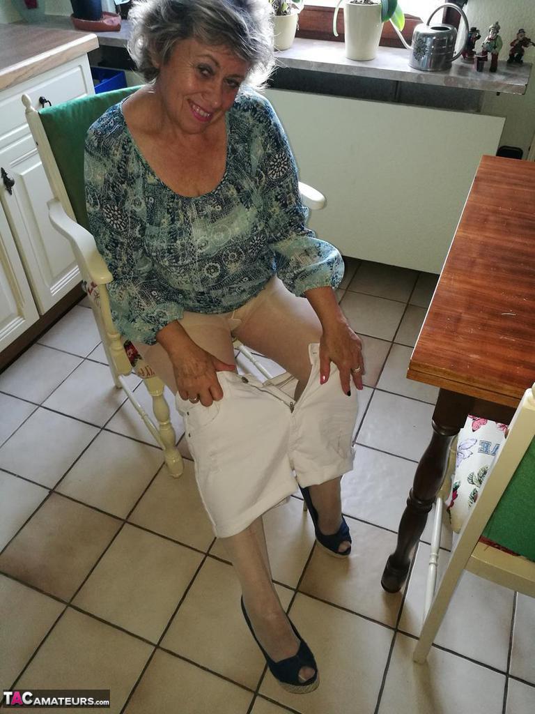 Horny granny Caro sticks a banana inside her natural pussy on kitchen chair(17)