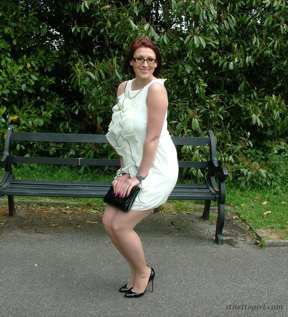 Thick woman in glasses shows off her stiletto heels on a park bench(3)