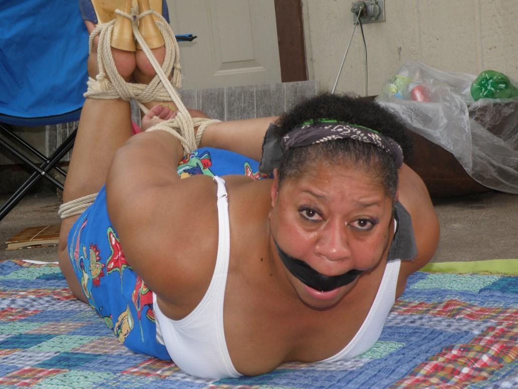 Mature ebony plumper is hogtied on a comforter while cleave gagged(10)