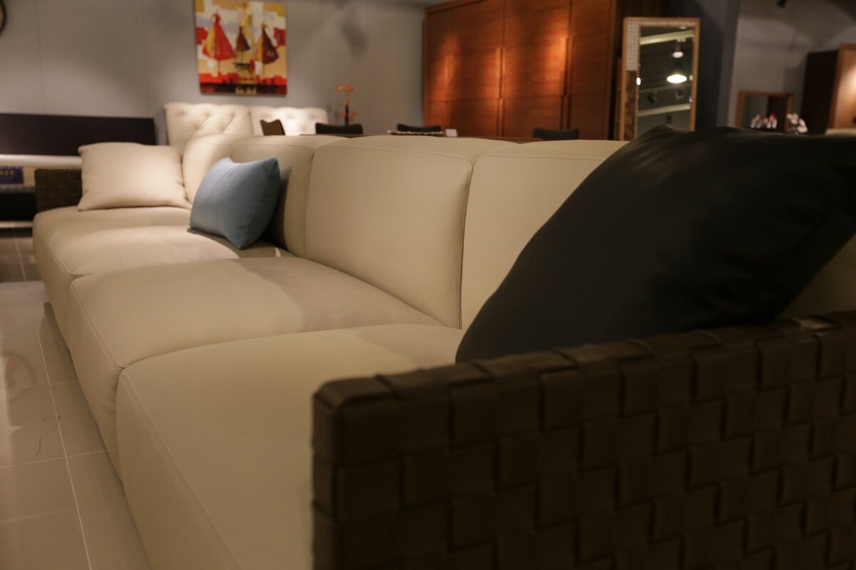 Low-angle shot of cream leather sofa in low-lit room