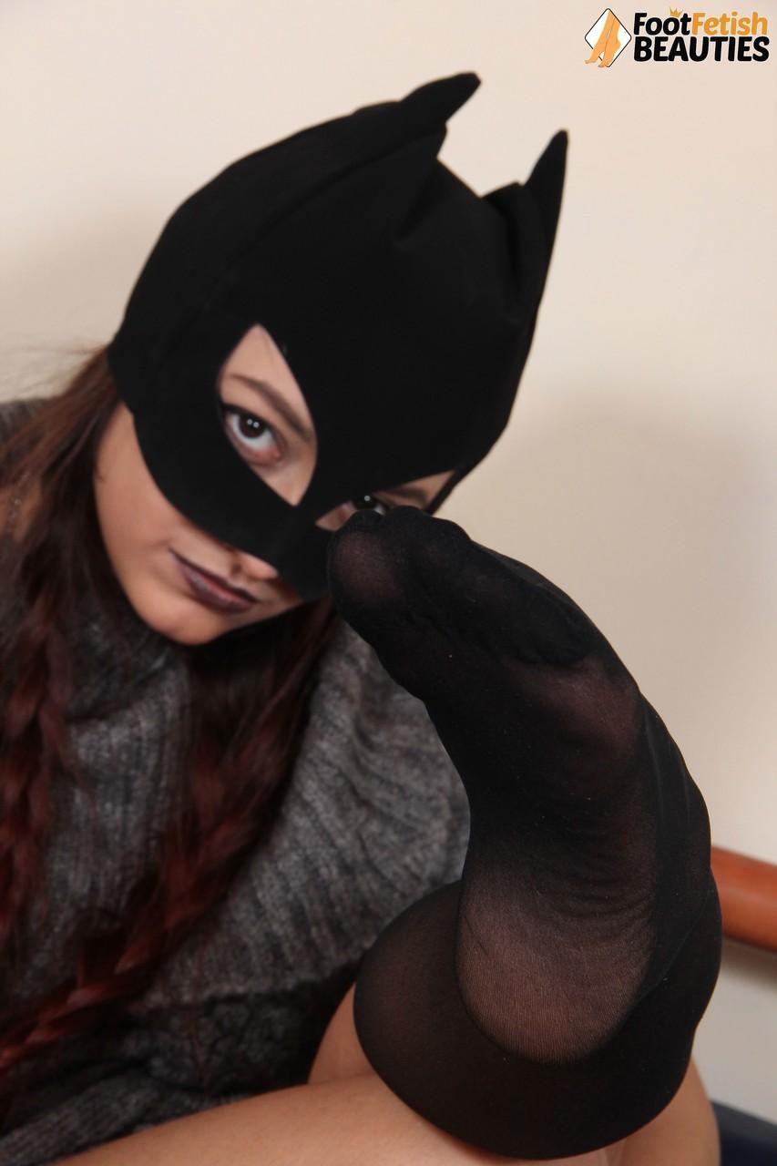 Clothed female Ladynight sports a mask while taking off her boots and socks(5)