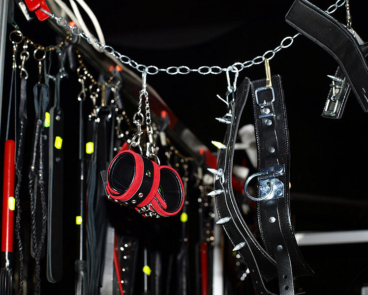Close-up of fetish gear including handcuffs and collars