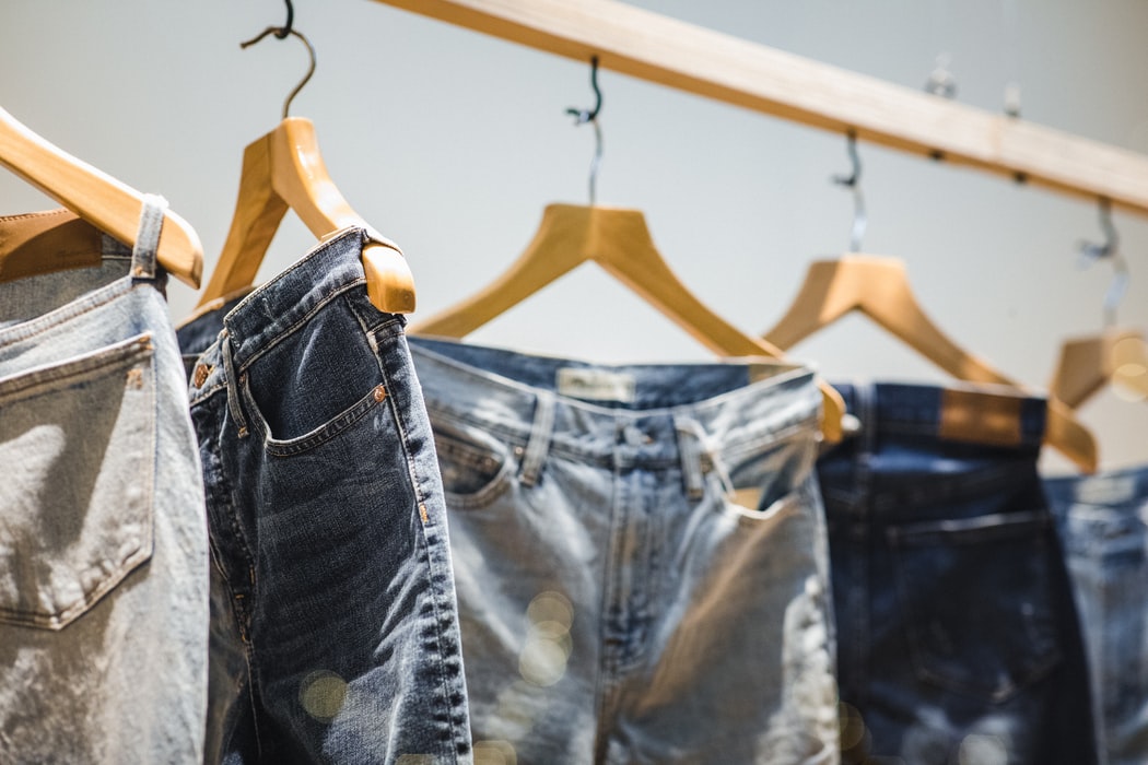 Assorted jeans hung on wardrobe railing