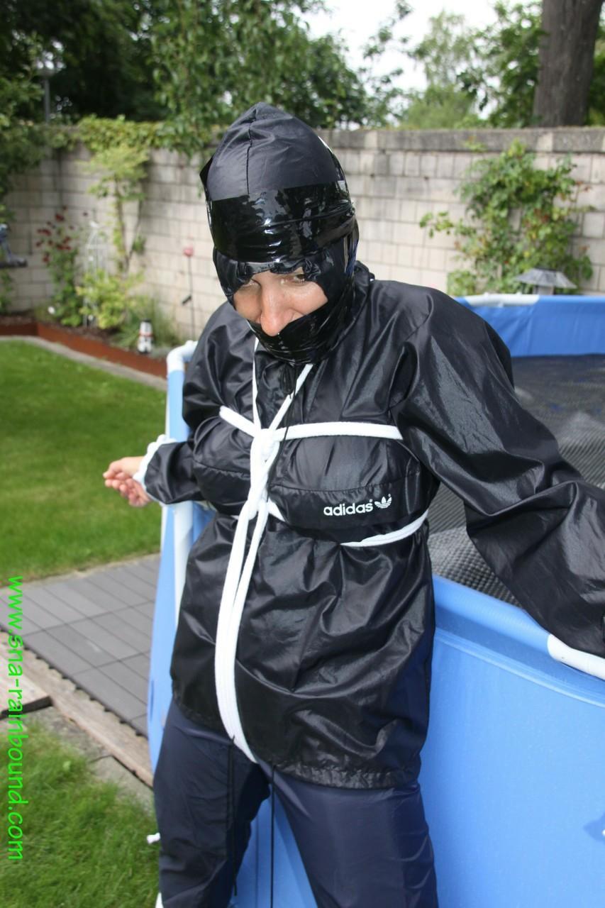 Amateur woman Sandra is gagged and tied to a pool in a raincoat(12)