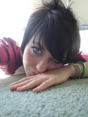 Short-haired punk chick with pierced nose, lip, navel in her own photos