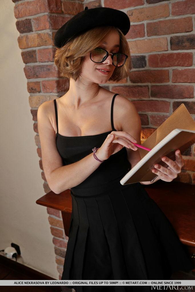 Cute teen Alice Nekrasova browses a hardcover book before going nude(2)