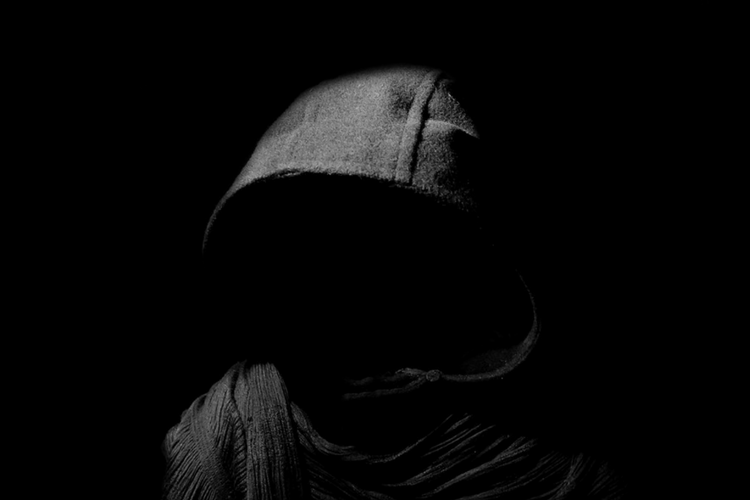 Hooded figure in the dark