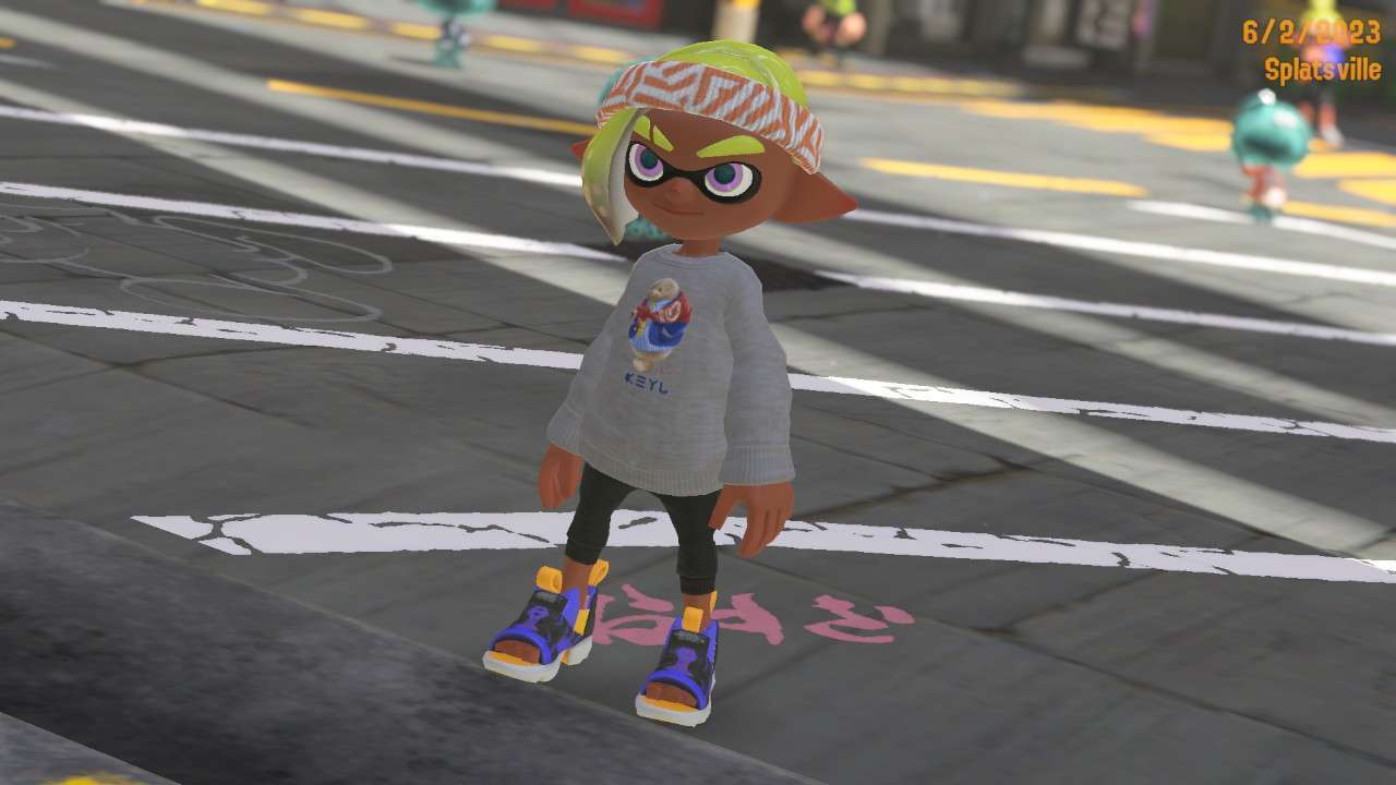 a photo of me, or my inkling self in splatsville. i'm wearing a grey sweater, black capri leggings, blue-and-black sandals, with a white and orange striped headband.