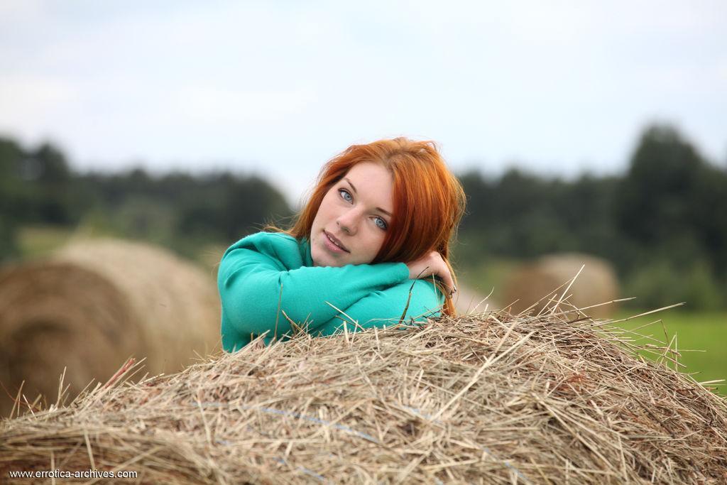 Natural redhead Amber A poses her naked teen body on round bale of hay(1)