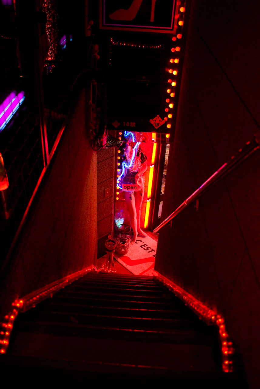 Neon lit staircase leading down into a sex toy shop