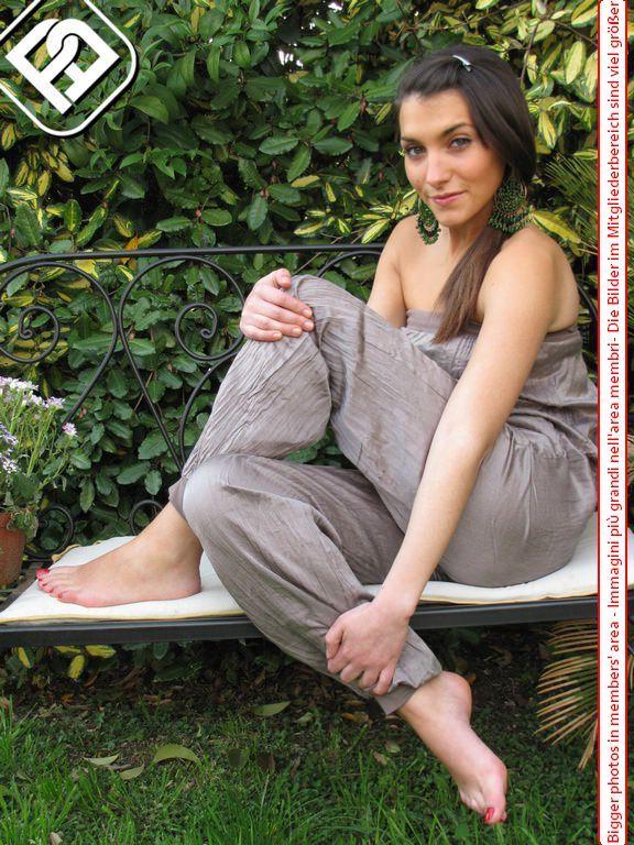 Pretty brunette displays her freshly painted toenails in a backyard(1)