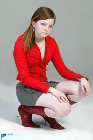 Pale redhead Lilly slowly strips to a black G-string and red leather boots