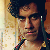 Sacha Dhawan as DI Honey wearing his flowery robe and holding a knife.