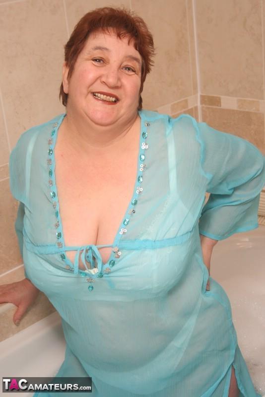 Redhead nan Kinky Carol parks her fat figure in a tub while fully clothed(12)