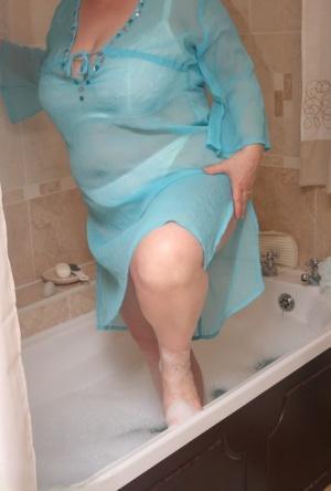 Redhead nan Kinky Carol parks her fat figure in a tub while fully clothed