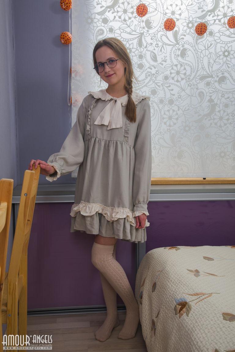 Nerdy girl takes off her dress and pretties along with her glasses on her bed(1)