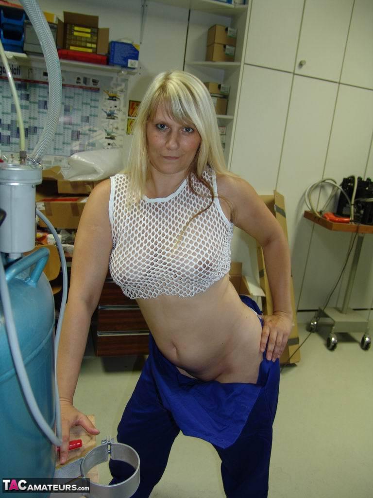 Mature blonde removes her overall before masturbating in workshop(4)