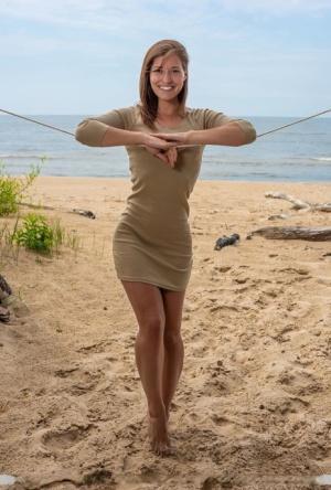 Tall teen Mina hangs wet clothes to dry while posing nude on a beach