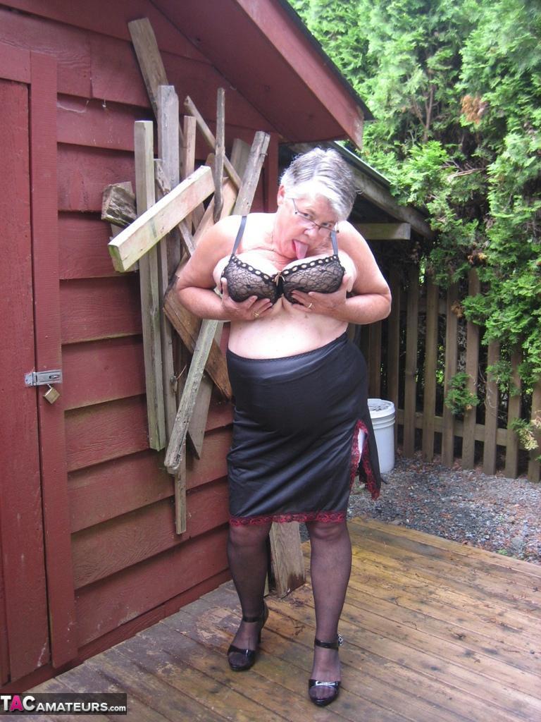 Fat oma Girdle Goddess unleashes her large boobs next to a boarded-up building(13)