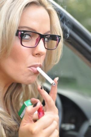 Blonde amateur Izzy puffs on a cigarette before showing her tits in a car