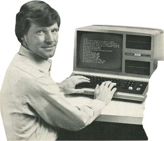 a monochrome image of a man in his thirties or forties. he has wavy short hair and a white dress shirt. he is sitting at an old-timey computer.